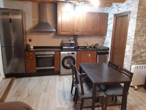 a kitchen with a table and a refrigerator at Casa Rural El Secreto del Castillo in Mora de Rubielos +24 photos