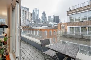 a balcony with a table and chairs on a building at Kula London - Tower Hill in London