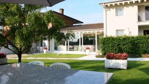 een huis met een tafel en stoelen in een tuin bij Residence Gonda&Giuliano in Borso del Grappa