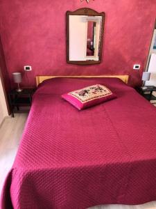 a bedroom with a pink bed with a mirror at levante rooms in Scalea