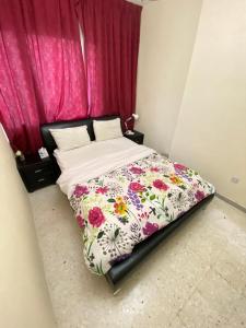 1 cama con edredón de flores en un dormitorio en MrKay, Couples should be married en Abu Dabi