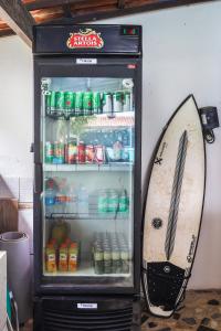 um frigorífico aberto com uma prancha de surf à frente em No Worries Pipa em Pipa