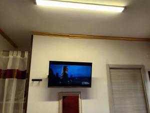 a flat screen tv hanging on a wall at levante rooms in Scalea