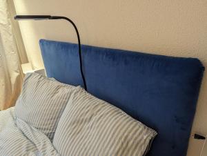 a blue head board with a pillow and a lamp at Lake Lucerne Paradise apartment in Brunnen