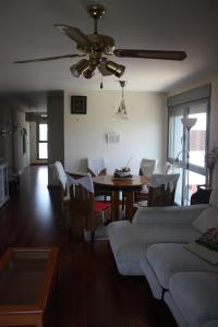 a living room with a table and a ceiling fan at Apartamento montaña MADI in Sabiñánigo