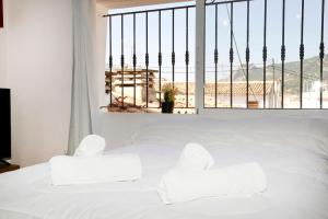 1 dormitorio con cama blanca y ventana grande en Ático con vistas a la montaña Alcoy, en Alcoy