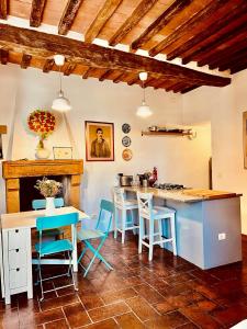 cocina con sillas azules, mesa y barra en Santa Monaca Medieval House, en Sorano