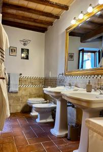 baño con 2 lavabos, espejo y aseo en Santa Monaca Medieval House, en Sorano