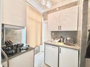 a kitchen with white cabinets and a sink at Imperial Suits in Istanbul