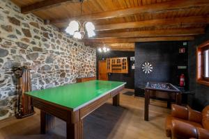 a ping pong table in a room with a stone wall at Casinha do Quadro in Figueiró dos Vinhos