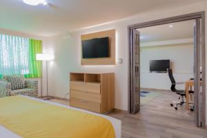 a hotel room with a bed and a desk and a television at La Joya Pachuca in Pachuca de Soto