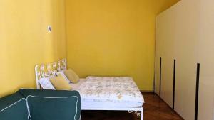 a bedroom with a bed and a yellow wall at Apartment Colors of Life in Rijeka