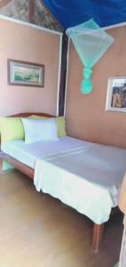 1 dormitorio con 1 cama con sombrilla en la pared en A&Z Nagtabon Lodge en Bacungan