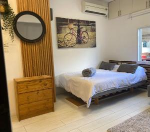 een slaapkamer met een bed en een spiegel bij סוויטה חדשה על חוף בוגרשוב המבוקש in Tel Aviv