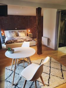 a bedroom with a bed and a table and chairs at L'Essentiel bis in Francorchamps