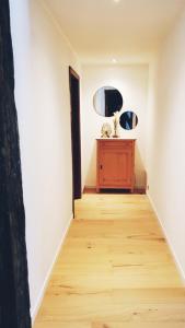 a hallway with a wooden floor and a mirror at L'Essentiel bis in Francorchamps