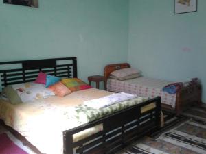 um quarto com 2 camas individuais em Maison d hôtes a Tioute Chez Abdelmajid em Tiout