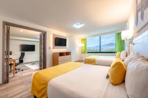 a hotel room with two beds and a large window at La Joya Pachuca in Pachuca de Soto