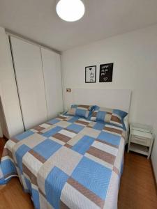 a bedroom with a bed with a blue and white blanket at Apart-hotel 1804 - Le Premier Suítes Jardim Paulista in Sao Paulo