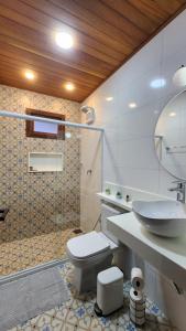 uma casa de banho com um WC branco e um lavatório. em Chalés Monte das Oliveiras em Domingos Martins