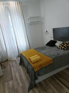a bedroom with a bed with a yellow blanket on it at Habitaciones Centro de Madrid in Madrid