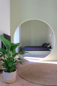 a bedroom with a mirror and a plant in a room at Civita Boutique in Catania