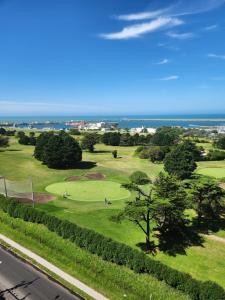 uma vista para um campo de golfe com o oceano ao fundo em Departamento Playa Grande Alem Golf em Mar del Plata