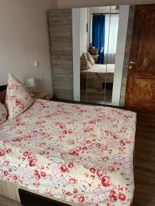 una camera da letto con un letto con fiori rossi di Apartament IOANA a Deva