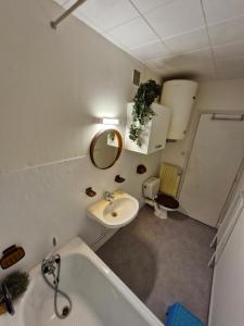 La salle de bains est pourvue d'un lavabo, de toilettes et d'une baignoire. dans l'établissement Studio - Pleine Mer - 1 avenue des Pays de Monts - 1-1, à Saint-Jean-de-Monts
