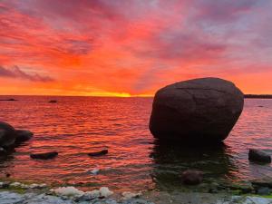 een rots in het water met een zonsondergang bij Kliff Butiik Majutus ja Restoran in Panga