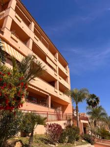 a large building with palm trees in front of it at Biasa Holidays in Torrox Costa