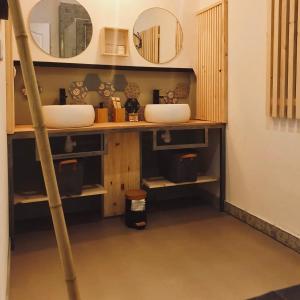 uma casa de banho com dois lavatórios e dois espelhos em Chambres d'Hôtes du Domaine de Bourbacoup em Tulle