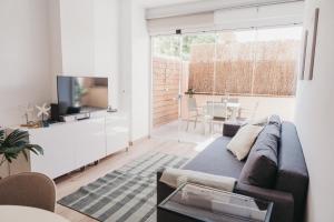 een woonkamer met een bank en een televisie bij Biasa Holidays in Torrox Costa
