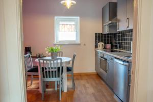 a small kitchen with a table and a table and chairs at Ferienwohnung im Herzen von Itzehoe mit eigenem Eingang in Itzehoe
