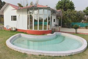 a swimming pool in the yard of a house at RAHA FARM in Noida