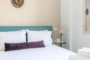 a bed with a purple pillow on top of it at Luxury Suite 3 in Himara in Himare