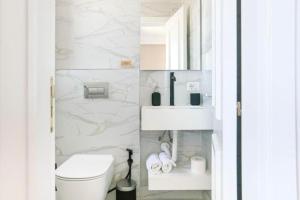 a white bathroom with a toilet and a sink at Luxury Suite 3 in Himara in Himare