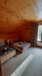 a bedroom with two beds in a wooden cabin at Карпатський затишок in Oryavchyk