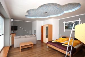 Apartments Furman - Self check-in في Rakek: غرفة معيشة مع سرير وجدارية سحابة على السقف