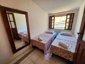 um quarto com 2 camas e um espelho em Apartamento no Paraiso Praia do Flamengo em Salvador