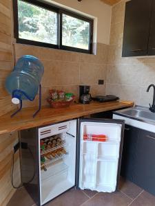 a kitchen with an open refrigerator and a sink at Glamping Caelum. Refugio al aire libre, en Macheta Cundinamarca in Machetá