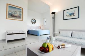 una sala de estar con una mesa con un bol de fruta en El Sol Hotel, en Kapsálion