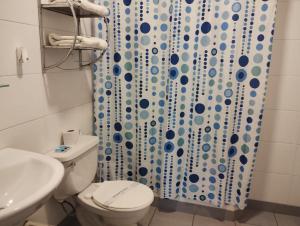 a bathroom with a toilet and a shower curtain at The Place Miraflores in Lima
