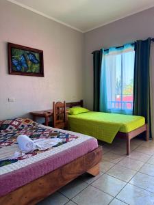 een slaapkamer met twee bedden en een raam bij Hotel La Fiore de Bahia in Uvita +62 foto's