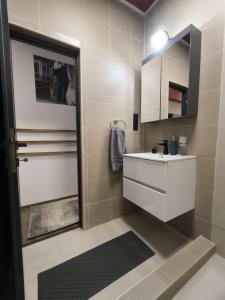 a bathroom with a white sink and a mirror at Morrison Rezidence in Miercurea-Ciuc +17 photos