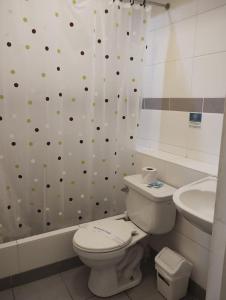 a bathroom with a toilet and a sink at The Place Miraflores in Lima