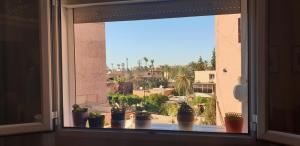 Bel appartement moderne au cœur de guelize في مراكش: نافذة مع مجموعة من الفخار