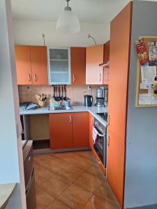 a small kitchen with orange cabinets and a stove at Witkowska-nocleg in Wrocław