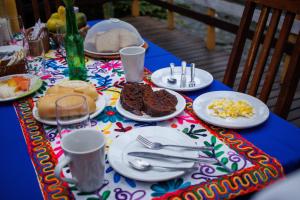 uma mesa com pratos de comida numa toalha de mesa colorida em Pousada cachoeira de Paraty em Sertão do Taquari