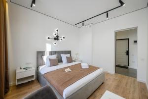 een slaapkamer met een groot bed en een stoel bij 5 NEW BUSINESS-CLASS APARTMENTS R-HOUSE near MEGA in Alma-Ata